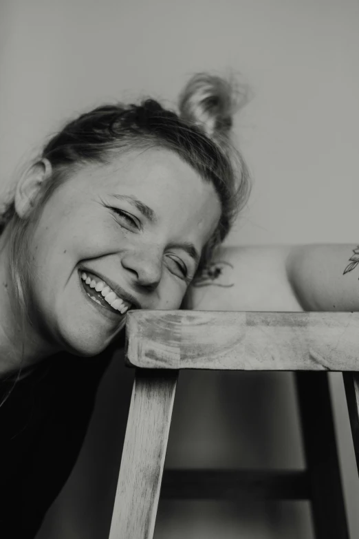 black and white pograph of smiling woman near ladder