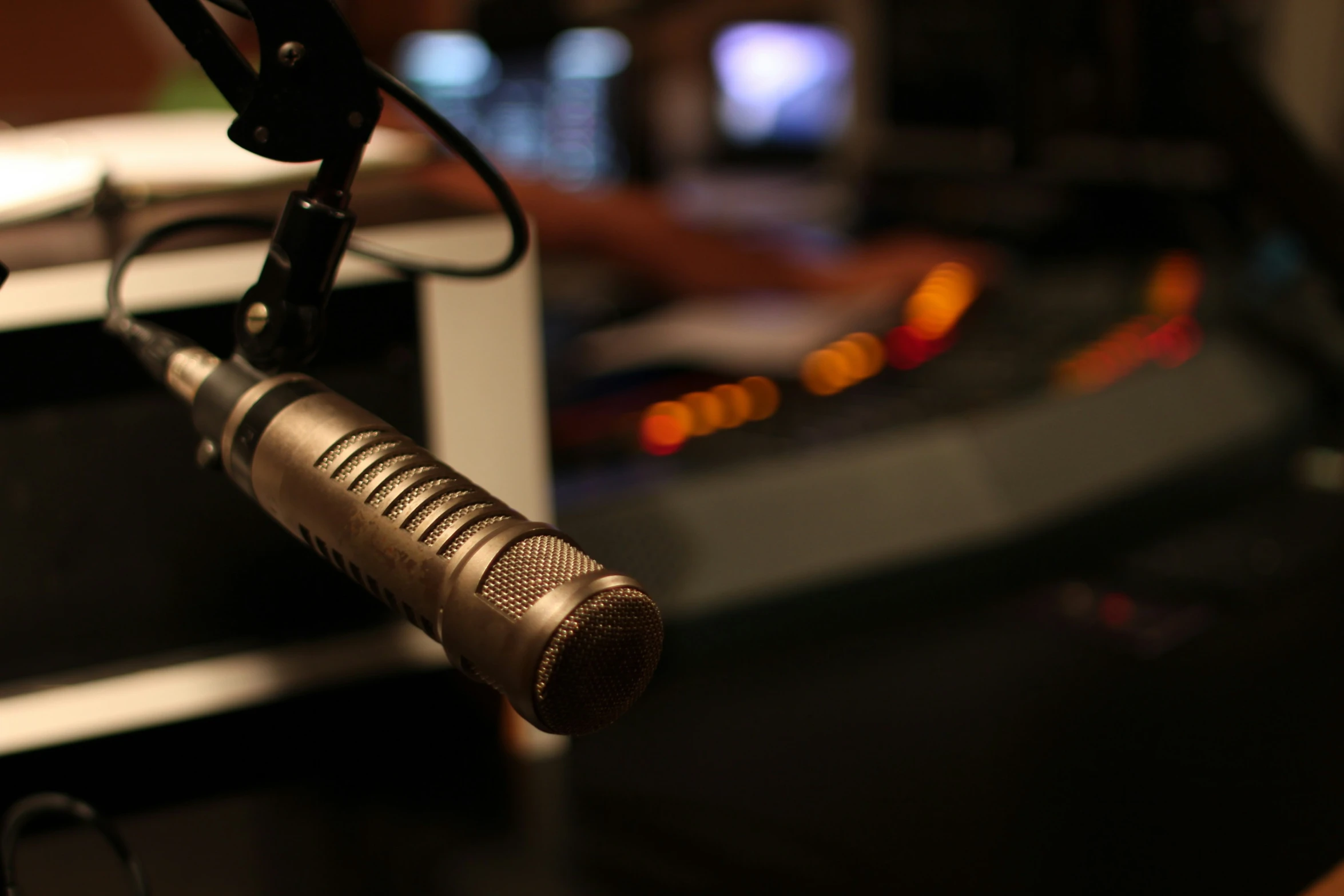 a microphone sits on a black table with blurry lights in the background