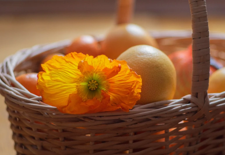 a basket full of fruit with an orange flower