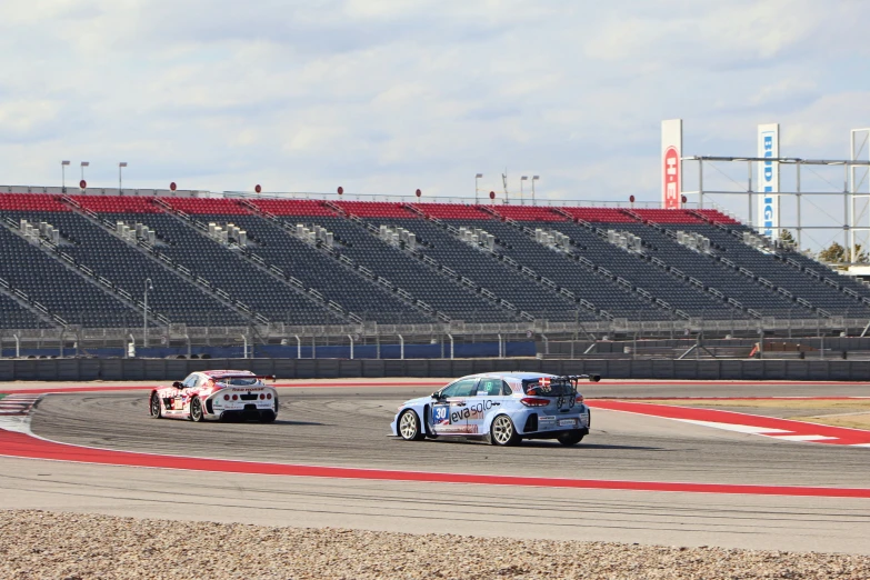 the cars are racing on a track during the day