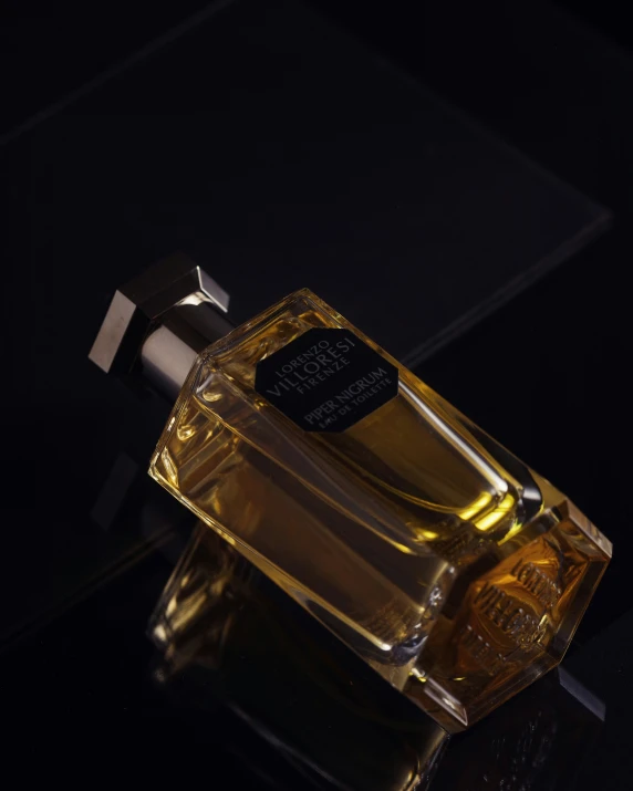 a bottle of perfume sitting on top of a black table