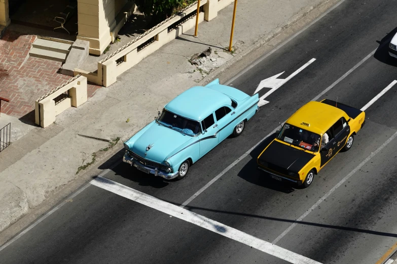 a couple of cars are in the road near some buildings