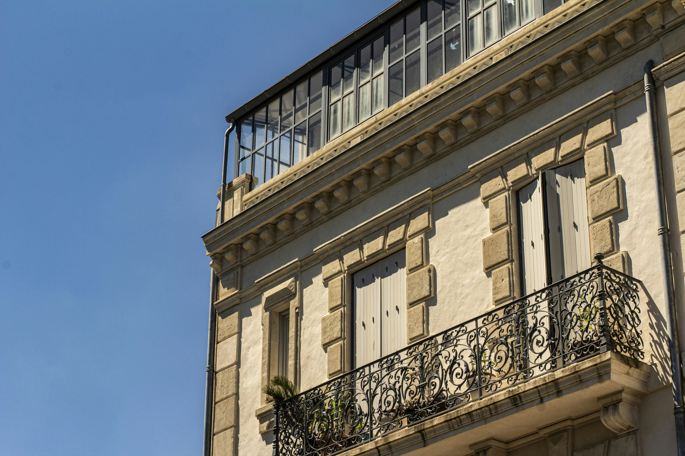 an old building with an iron balcony has a wrought iron railing and clock on the second story