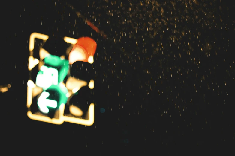 a traffic light in a rain storm at night