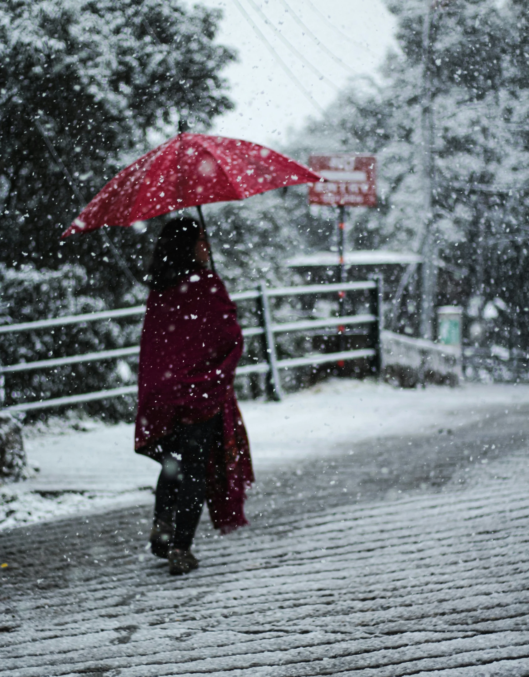 a woman in red coat holding an umbrella