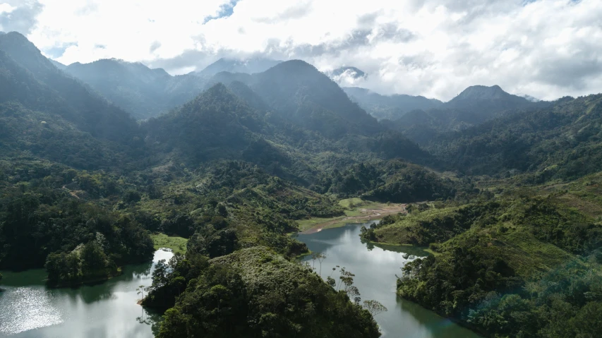 large mountains and trees surround an almost empty river