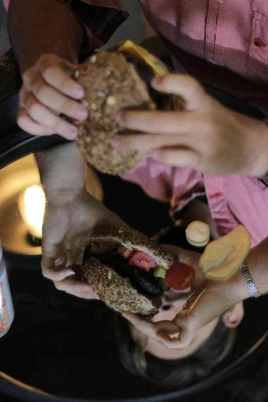 a group of people eating some sandwiches together