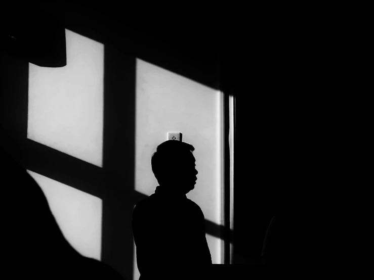 a person standing in front of a window and a shadow