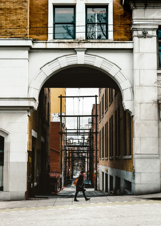 two men are walking through an arch on a street