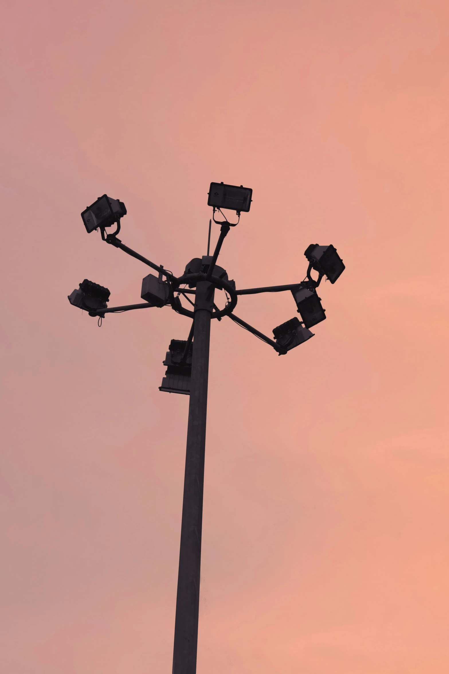 square cameras on top of an antenna pole at sunset