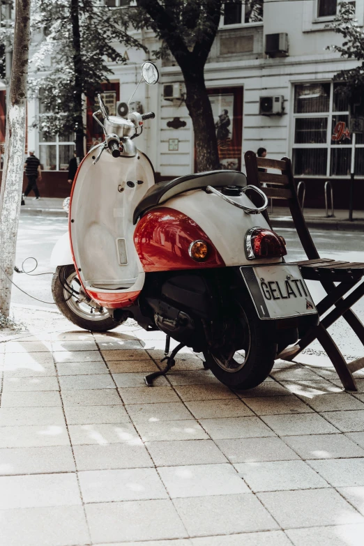 the red motorcycle is parked by the tree