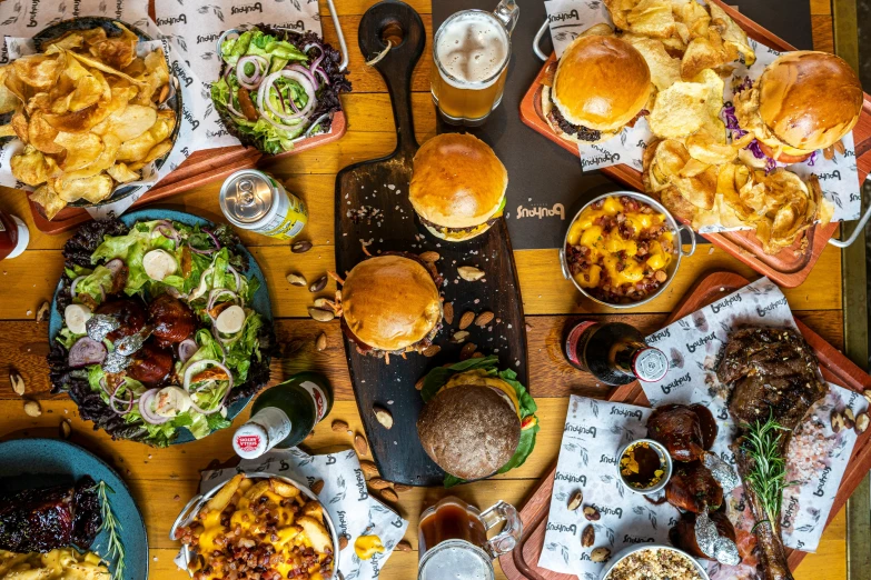 overhead view of hamburgers, hamburger rings, onion rings, salad and sides