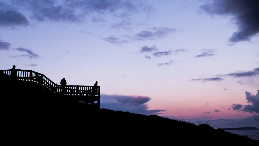 two people are standing on a stair leading to the top of a hill