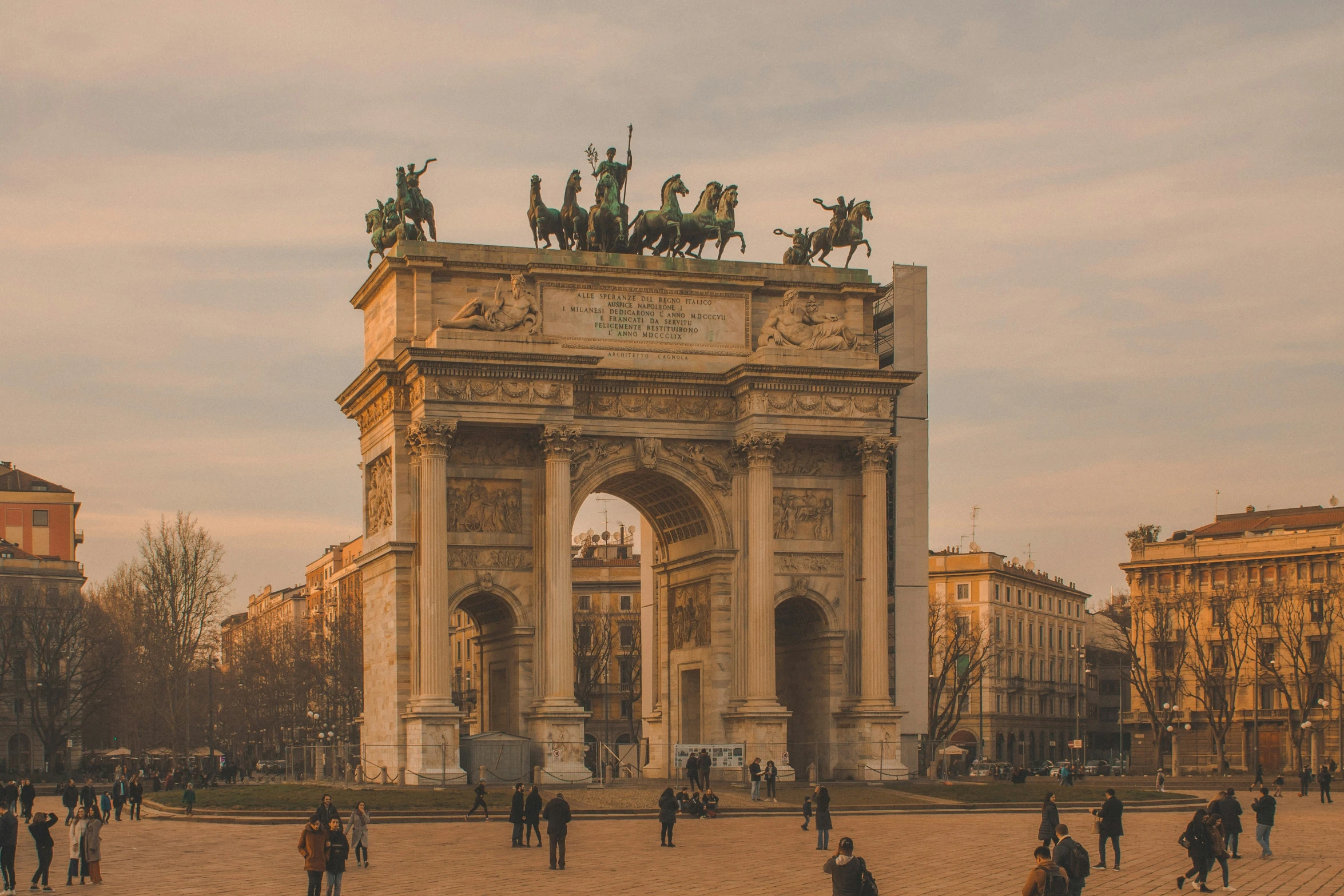 people are standing near the stone arch in paris