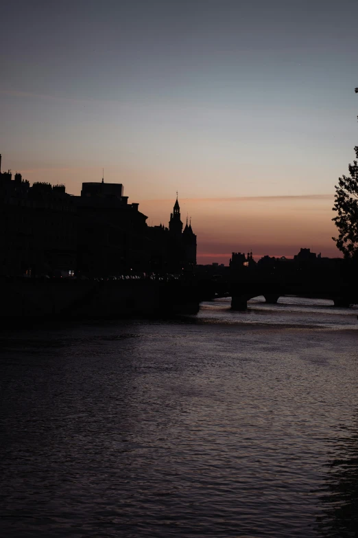 sunset over a river with buildings and water