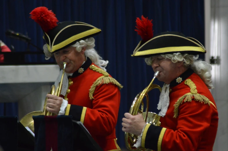 two musicians playing instruments with big red hats