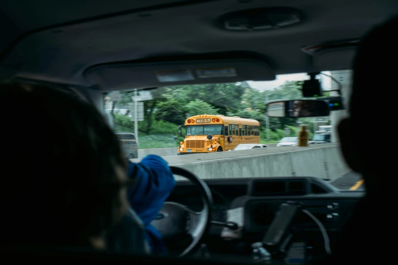 a bus is passing by an overpass and another bus is waiting at it