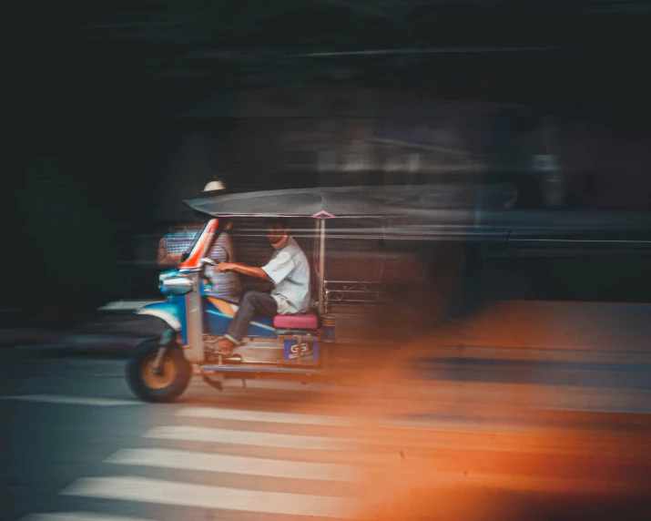 a man rides on the back of a moped in traffic