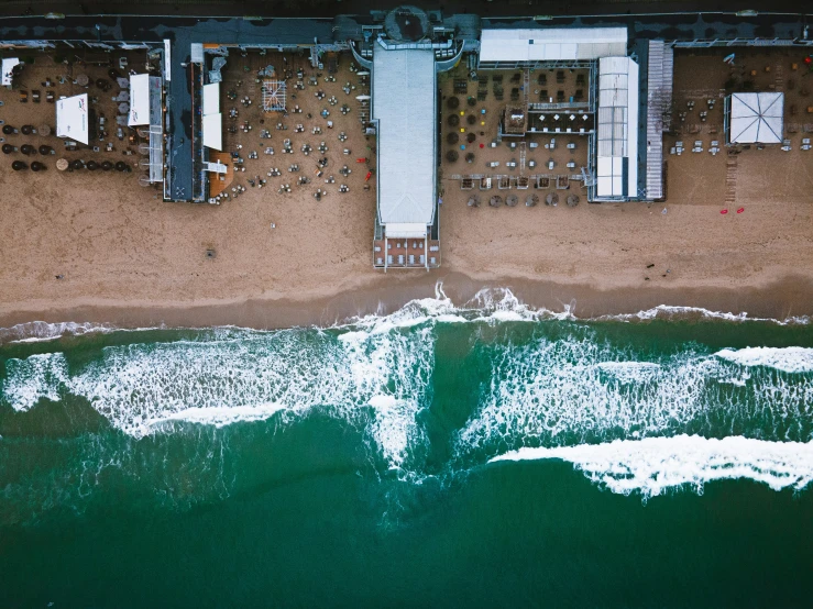 an aerial po of some tables by the ocean