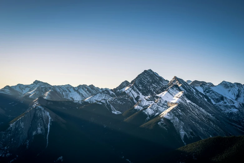 an airplane flies low in the air over snowy mountain peaks