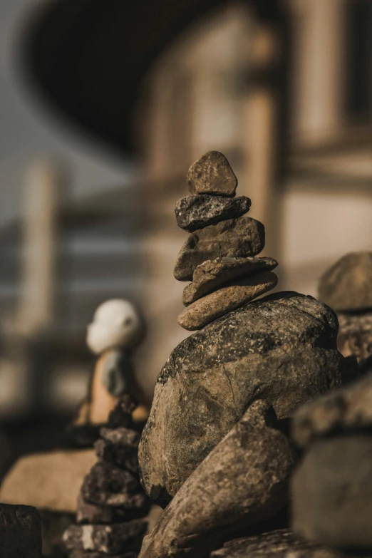 several rocks balanced together next to a house