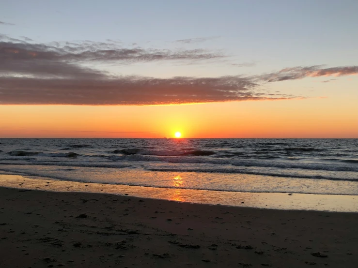 a sunset over the ocean with the ocean waves