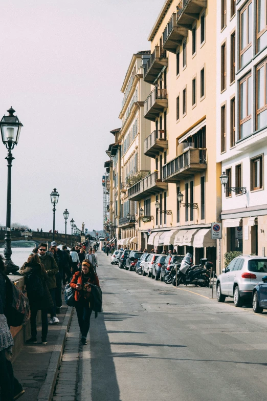 the people are walking in the long row along the road