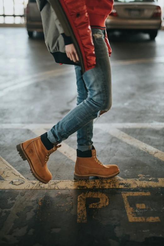 a person wearing brown boots and blue jeans is riding on top of an ice skateboard