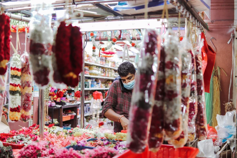 an indian man is looking at some kind of flowers for sale