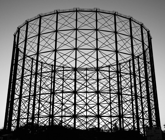 the silhouette of a large metal structure against a light blue sky