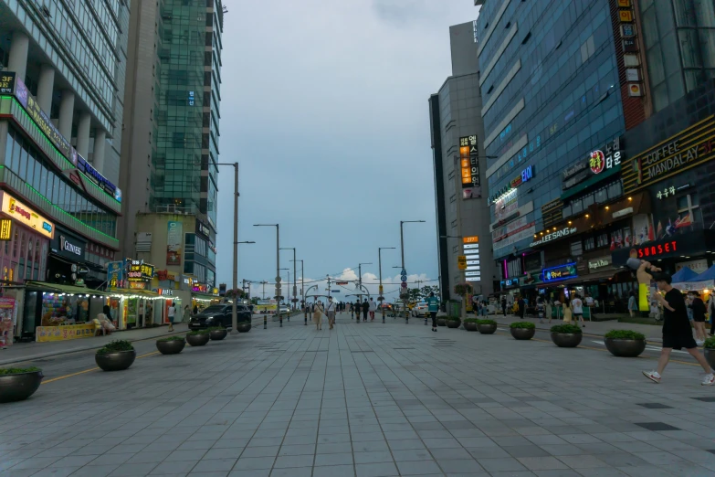 pedestrians walk down an empty street in a city