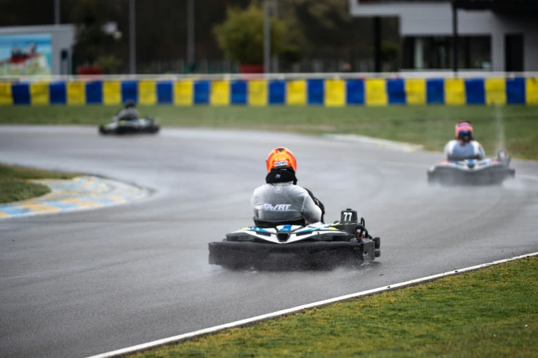 two people riding on a large oval car in the rain