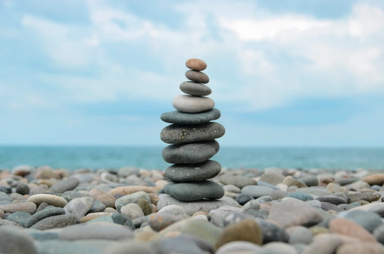 stones stacked together on the beach by the water