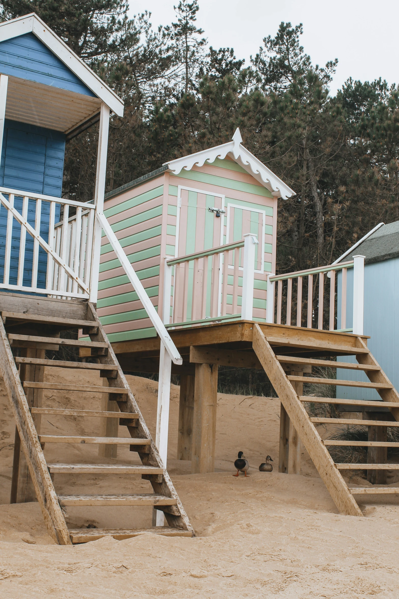 three lifeguard huts at the beach with steps and stairs leading up to them