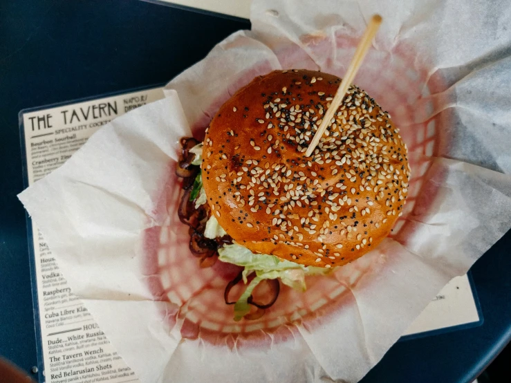 a large hamburger is on top of some paper