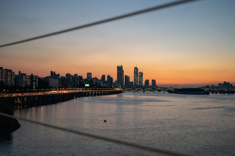 the skyline is lit up at dusk from the water