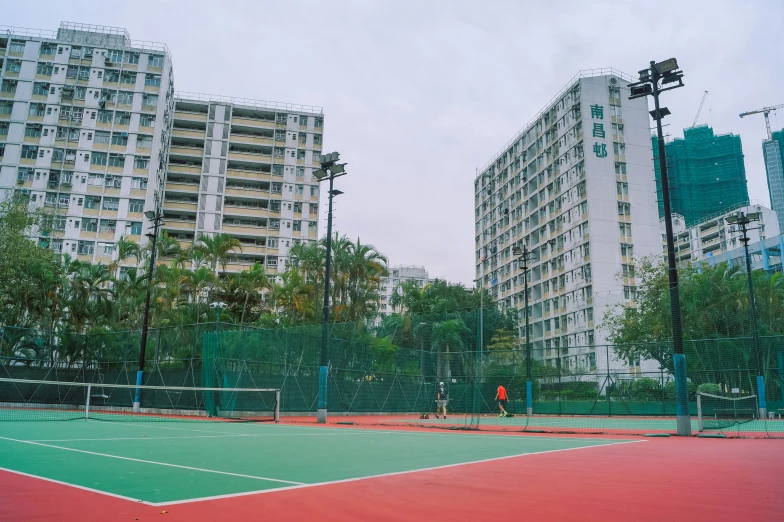 two large white buildings next to a tennis court