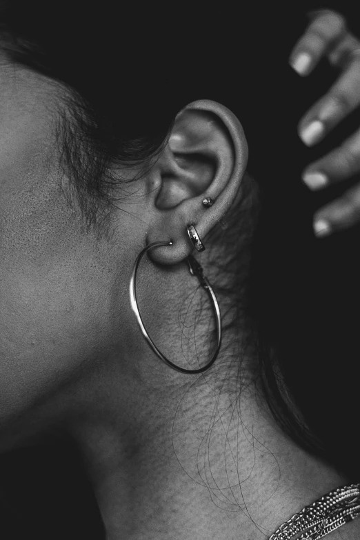 a woman in profile with a large earrings on her ear