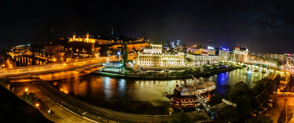 a large city sits next to some water at night