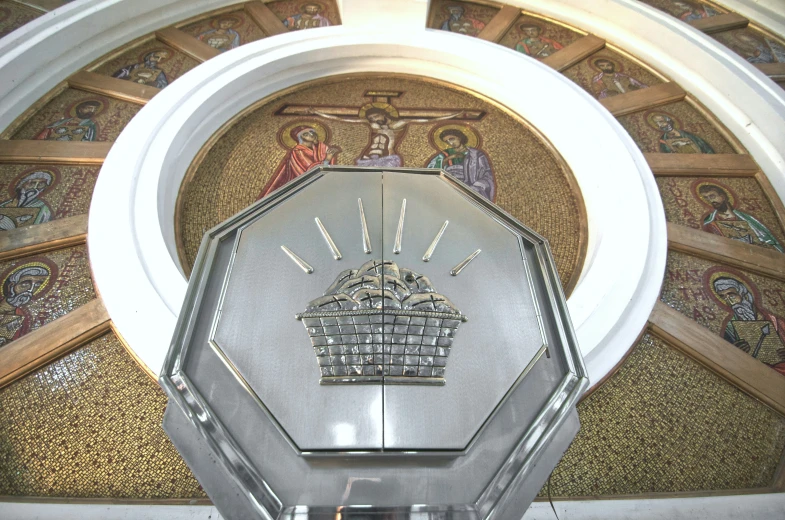 an ornate silver clock with gold trim and paintings on the ceiling