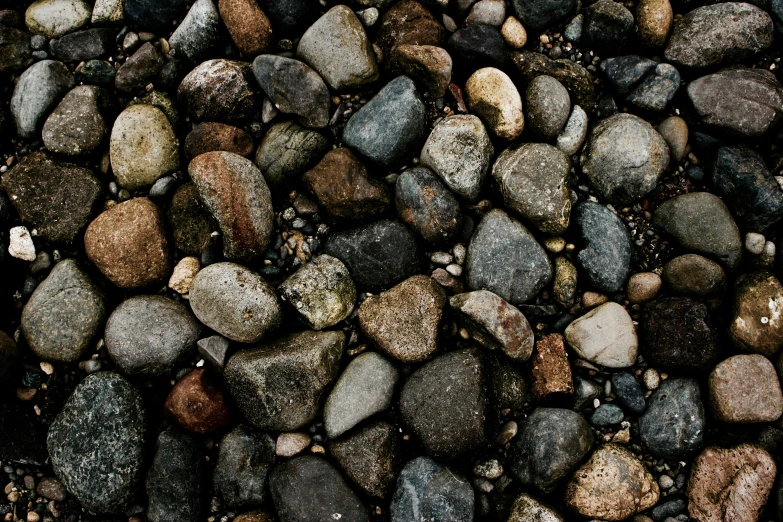 gravel stones scattered in large pile with water coming out