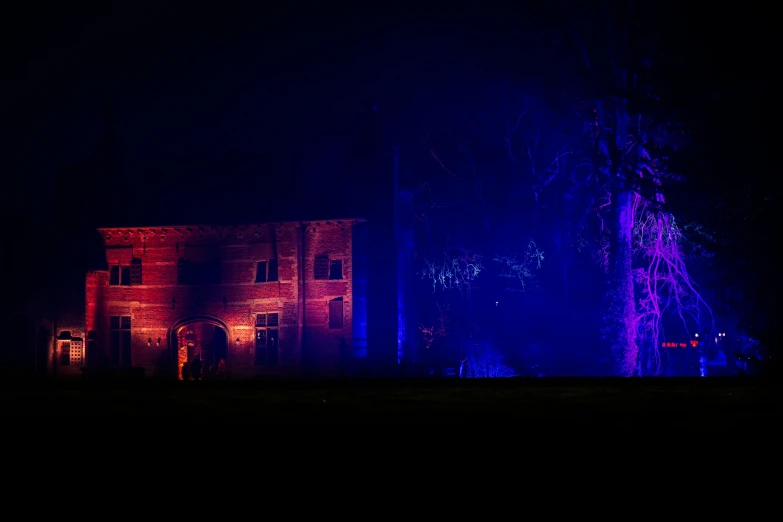 an illuminated building is shown in the dark