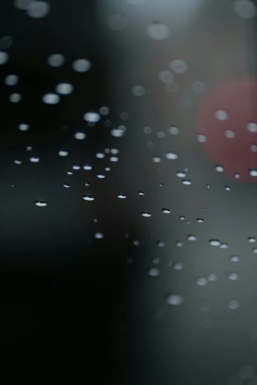 raindrops on the glass with a red street sign in the distance