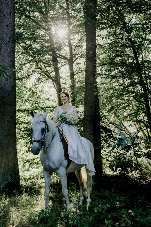 a woman in long sleeves riding a horse in the woods