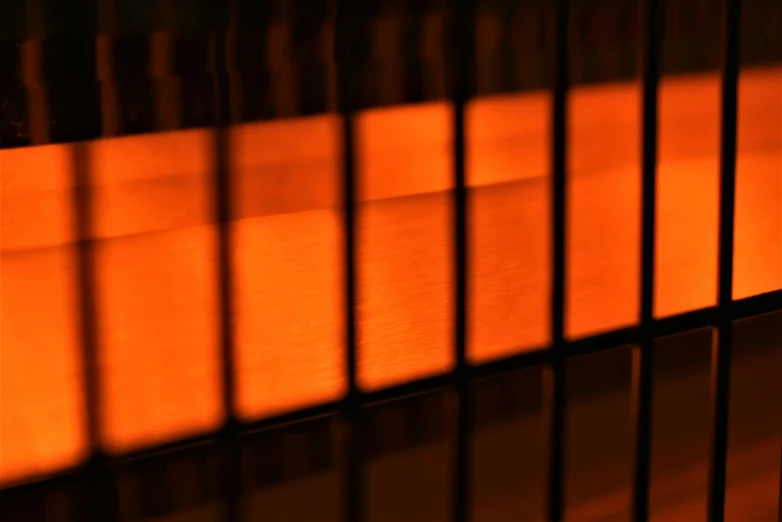 a closeup of the light from a lamp shines bright on a wood paneled wall