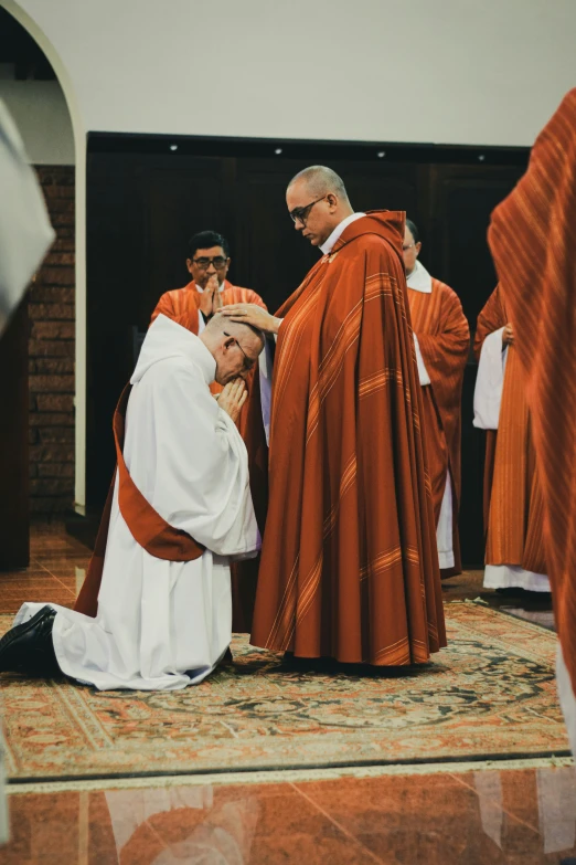 an image of priest praying with people in background
