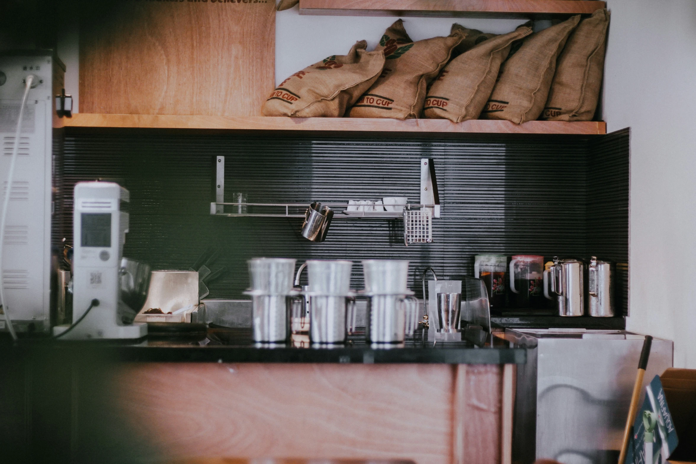 a coffee pot and cups are on a counter