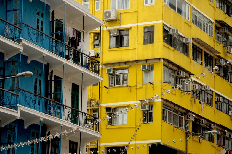 some buildings with windows are painted yellow and blue
