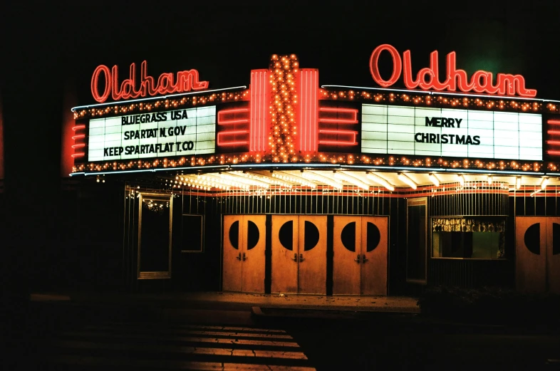 an illuminated theatre marquee at night with a number of lights on