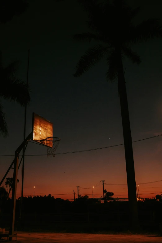 a basketball hoop in the air with a lot of dark lighting in the background